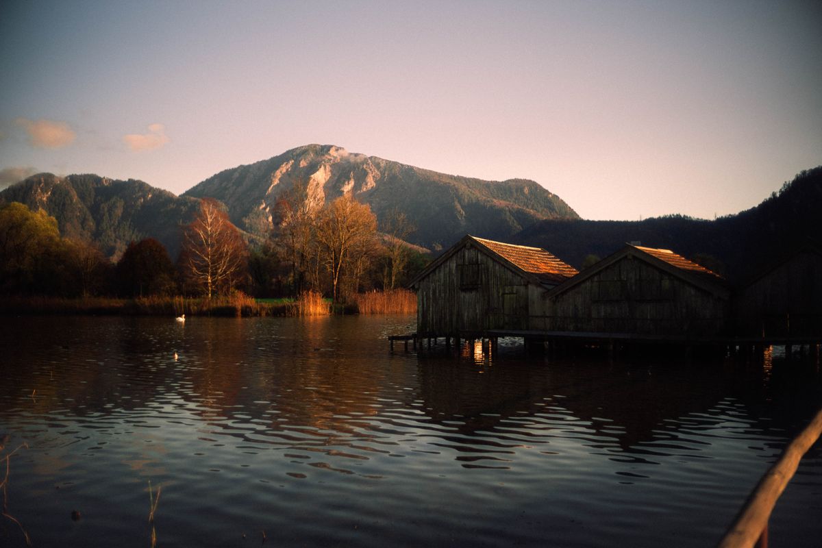 Illustrative stock photo of wooden cabins at the edge of a lake